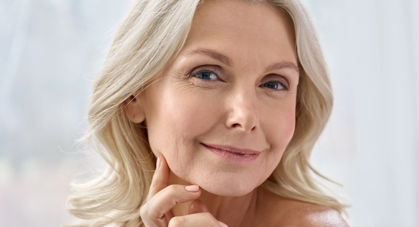 mature blonde woman touching her face