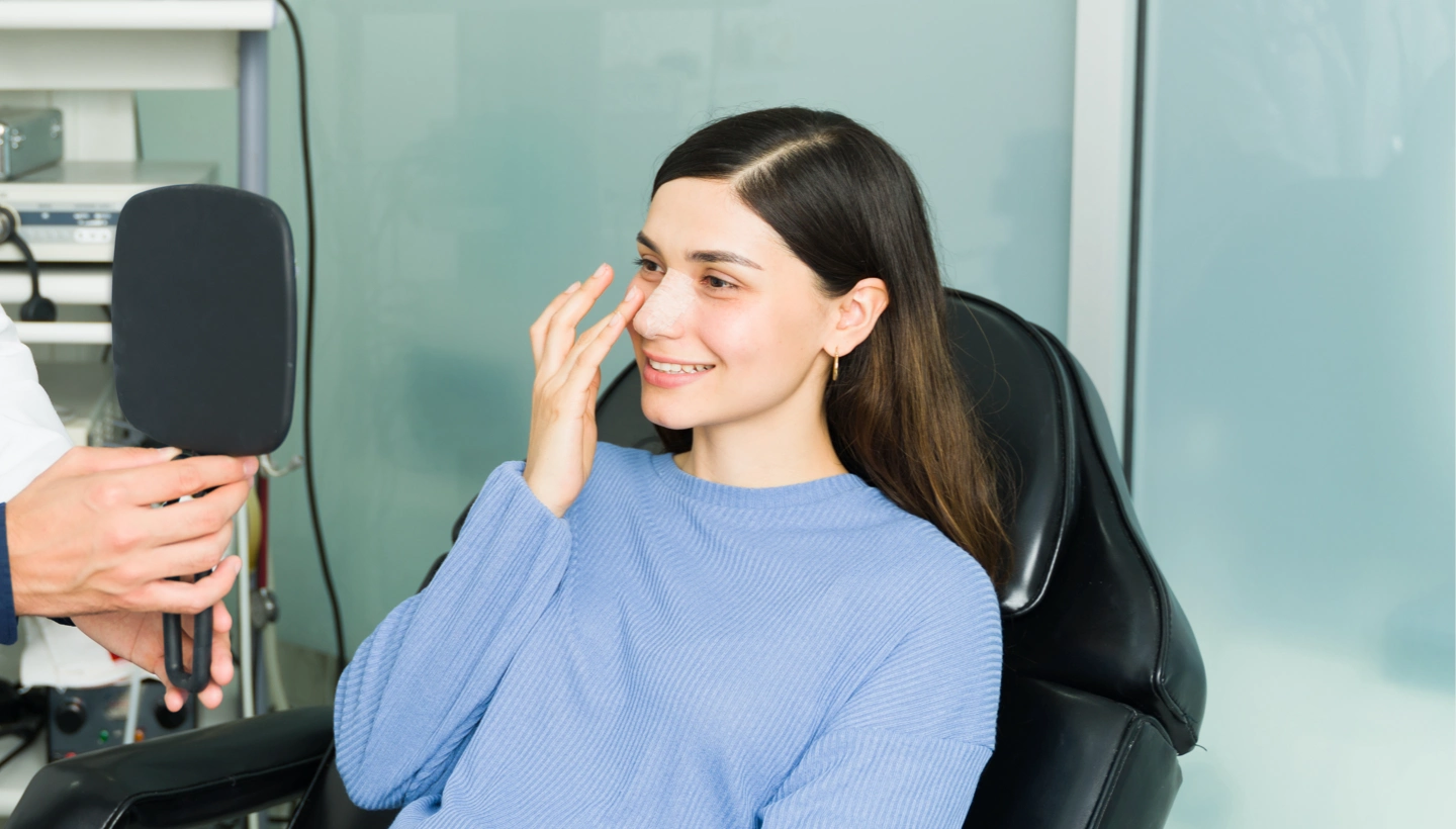 woman looking at her nose in a mirror